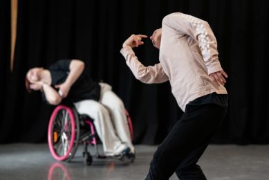 Two dancers bending sideways one in foreground and the other out of focus in background